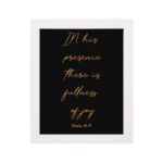 In His presence, there is fullness of joy in gold cursive text on a black background with Psalm 16:11 hung on the wall in a white frame - Christian wall art for home decor.