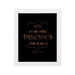 Black wall art with gold text saying SHE IS FAR MORE PRECIOUS THAN JEWELS from Proverbs 31:10, styled with decorative elements. hung on the wall in a white frame