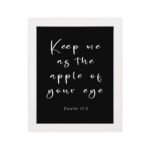 Keep Me As The Apple Of Your Eye Psalm 17:8 white cursive text on black background - Christian wall art for home decor hung on the wall in a white frame