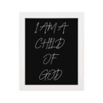 I Am A Child Of God Bible wall art with white handwritten text on a black background Wall Art hung on the wall in a white frame