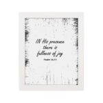 In His Presence There Is Fullness of Joy - Psalm 16:11 Bible Verse Wall Art with Bold Black Text and Distressed Edges on White Background Wall Art hung on the wall in white frame