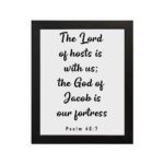 The Lord Of Hosts Is With Us - Psalm 46:7 Bible Verse Wall Art with White Text on Light Background Framed in Black Wall Art hung on the wall in black frame