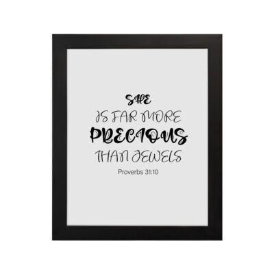 Christian wall art with black text on a white background reading She is far more precious than jewels from Proverbs 31:10 in two font styles. hung on the wall in a black frame