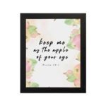 Keep Me As The Apple Of Your Eye Psalm 17:8 Bible Verse Wall Art with apple and leaf design, soft pastel colors, and white background. Wall Art hung on the wall in black frame