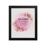 The Lord My God Lights Up My Darkness Psalm 18:28 Bible Verse Wall Art with black text on a soft pink watercolor background and delicate floral accents. Wall Art hung on the wall in black frame