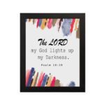 The Lord My God Lights Up My Darkness Psalm 18:28 Bible Verse Wall Art with black text and bold red, orange, blue, and yellow brush strokes on a white background. Wall Art hung on the wall in a black frame