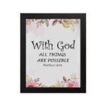 With God All Things Are Possible Matthew 19:26 Bible Verse Wall Art with black text and floral accents in pink and green on a white background. Wall Art hung on the wall in black frame