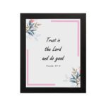 Infidu Bible wall art featuring Psalm 37:3 in black text with blue and pink floral accents and a soft pink border. Wall Art hung on the wall in a black frame