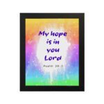 Infidu My Hope Is In You Lord Psalm 39:7 Bible Wall Art with bright blue and pink text and colorful watercolor background Wall Art hung on the wall in a black frame