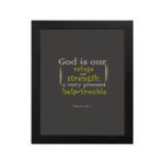 Psalm 46:1 Bible Wall Art with muted text on a dark gray background, featuring varying fonts and sizes. Wall Art hung on the wall in a black frame