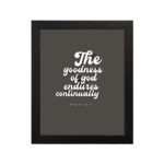 The Goodness of God Endures Continually Psalm 52:1 Christian wall art with white text on a dark gray background. Wall Art hung on the wall in black frame