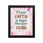 Christian wall art with brown 'Faith' and 'Fear' text, pink leaves, and a light pink floral background. Wall Art hung on the wall in a black frame