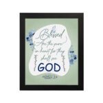 Infidu Matthew 5:8 Christian wall art with silver and dark blue text on a pale green background, featuring 'GOD' in a white oval and blue floral designs. Wall Art hung on the wall in a black frame