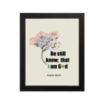 Be Still and Know That I Am God Psalm 46:10 Bible verse wall art with tree graphic, black and green text on a white background. hung on the wall in a black frame