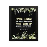 The Lord of Hosts is With Us Psalm 46:7 Bible Verse Wall Art with green leaves and bold cream and white text. hung on the wall in a black frame