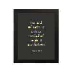 Psalm 46:7 Bible Verse Christian Wall Art - The Lord of Hosts is With Us, Minimalistic Design with Gold Accents. hung on the wall in a black frame