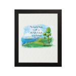 Psalm 46:7 Bible verse wall art with serene watercolor landscape of trees, hills, and water, featuring the verse in black text. hung on the wall in a black frame