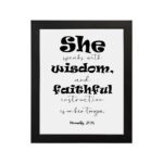 Proverbs 31:26 Bible wall art featuring bold and simple fonts on a white background, framed in black, highlighting the message of wisdom. hung on the wall in a black frame