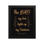 The Lord My God Lights Up My Darkness Psalm 18:28 gold text on black background Christian wall art hung on the wall in a black frame