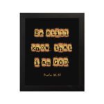 Be Still and Know That I Am God - Psalm 46:10 Bible Verse Wall Art with Scrabble-like Letters on Dark Background Wall Art hung on the wall in a black frame