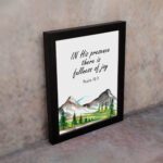 In His Presence There Is Fullness of Joy - Psalm 16:11 Bible Verse Wall Art with Mountains and Trees on White Background Wall Art displayed on the wall in a black frame