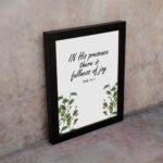 In His Presence There Is Fullness of Joy - Psalm 16:11 Bible Verse Wall Art with Green Leaf Design on White Background Wall Art displayed on the wall in a black frame