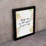 Keep Me As The Apple Of Your Eye Psalm 17:8 Bible Verse Wall Art with apple and leaf design, soft pastel colors, and white background. Wall Art displayed on the wall in black frame