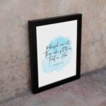 Serene Bible verse wall art with Psalm 2:12 and soft blue watercolor design, perfect for peaceful home decor. Wall Art displayed on the wall in a black frame