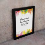 Vibrant Bible wall art with Psalm 2:12 verse and colorful paint splash in green, yellow, pink, and orange. Wall Art displayed on the wall in a black frame