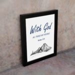 With God All Things Are Possible Matthew 19:26 Bible Verse Wall Art with dark blue text and mountain sketch on white background. Wall Art displayed on the wall in a black frame