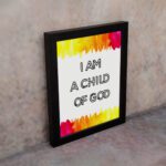 Infidu I Am A Child Of God Bible Wall Art with colorful watercolor borders and black block text on a white background Wall Art displayed on the wall in a black frame