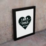 Infidu I Am A Child Of God Bible Wall Art with a dark green heart and white text on a white background Wall Art displayed on the wall in a black frame