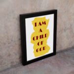 Infidu I Am A Child Of God Bible Wall Art with yellow shape and red text on a white background Wall Art displayed on the wall in a black frame