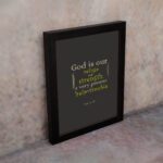 Psalm 46:1 Bible Wall Art with muted text on a dark gray background, featuring varying fonts and sizes. Wall Art displayed on the wall in a black frame