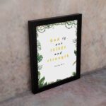 Psalm 46:1 Bible Wall Art with gold and black text, leafy green borders, and a white background. Wall Art displayed on the wall in a black frame