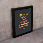 Psalm 46:1 Bible Wall Art with bold, colorful text on a deep black background. Wall Art displayed on the wall in a black frame