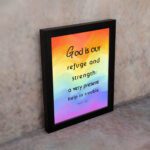 Psalm 46:1 Bible Wall Art with black vertical text on a vibrant rainbow gradient background. Wall Art displayed on the wall in a black frame