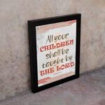 All Your Children Shall Be Taught By The Lord Isaiah 54:13 Christian Wall Art with red, brown, and beige tones. Wall Art displayed on the wall in a black frame