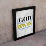 God Will Provide Christian wall art with bold black 'God,' gray and yellow text, and a heart-like light gray background. Wall Art displayed on the wall in a black frame