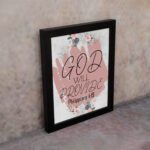 God Will Provide Philippians 4:19 Christian Wall Art with soft pink floral design Wall Art displayed on the wall in black frame