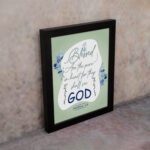 Infidu Matthew 5:8 Christian wall art with silver and dark blue text on a pale green background, featuring 'GOD' in a white oval and blue floral designs. Wall Art displayed on the wall in a black frame