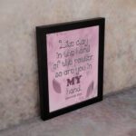 Infidu Jeremiah 18:6 Christian wall art with dark brown cursive text and bold 'MY' in brownish-purple, on a light pink background with leaf patterns. Wall Art displayed on the wall in a black frame