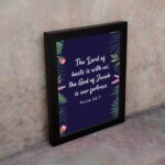 Infidu Fruit of the Spirit wall art featuring colorful fruits and words like Love, Joy, and Peace on a beige background. displayed on the wall in a black frame