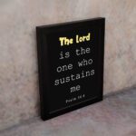 Psalm 54:4 Bible Verse Wall Art - The Lord Is The One Who Sustains Me in bold text on a black background for Christian home decor. Wall Art displayed on the wall in a black frame