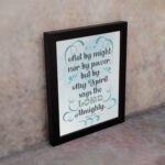 Zechariah 4:6 Bible verse wall art with light blue and white text, decorative flourishes, and a light blue gradient background. Inspiring Christian home decor. Wall Art on the kept wall in a black frame