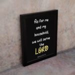 Joshua 24:15 Bible verse wall art with LORD in yellow on a black background. Inspiring Christian home decor by Infidu. Wall Art on the wall in a black frame