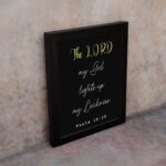 Psalm 18:28 Bible verse wall art with The LORD in yellow on a black background. Christian decor by Infidu. Wall Art displayed on the wall in a black frame