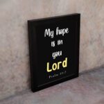 Psalm 39:7 Bible verse wall art with a black background, Lord in yellow. Christian home decor by Infidu. Wall Art kept on the wall in a black frame