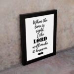 Infidu wall art displaying When the time is right, I, the LORD will make it happen in black text on a white background. displayed on the wall in a black frame