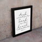 Matthew 7:7 Bible wall art in elegant cursive, highlighting Ask, Seek, and Knock on a white background. displayed on the wall in a black frame